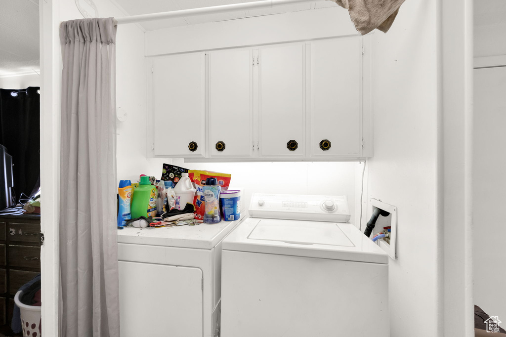 Washroom with washer and dryer and cabinets