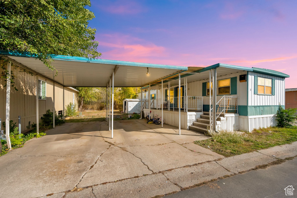 Manufactured / mobile home featuring covered porch and a carport