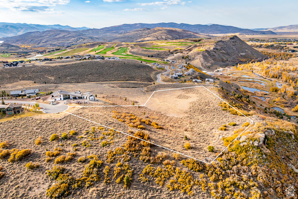 Aerial view of property's location with property parcel outlined and a mountain backdrop