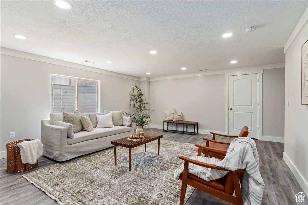 Living area with wood finished floors, recessed lighting, and a textured ceiling