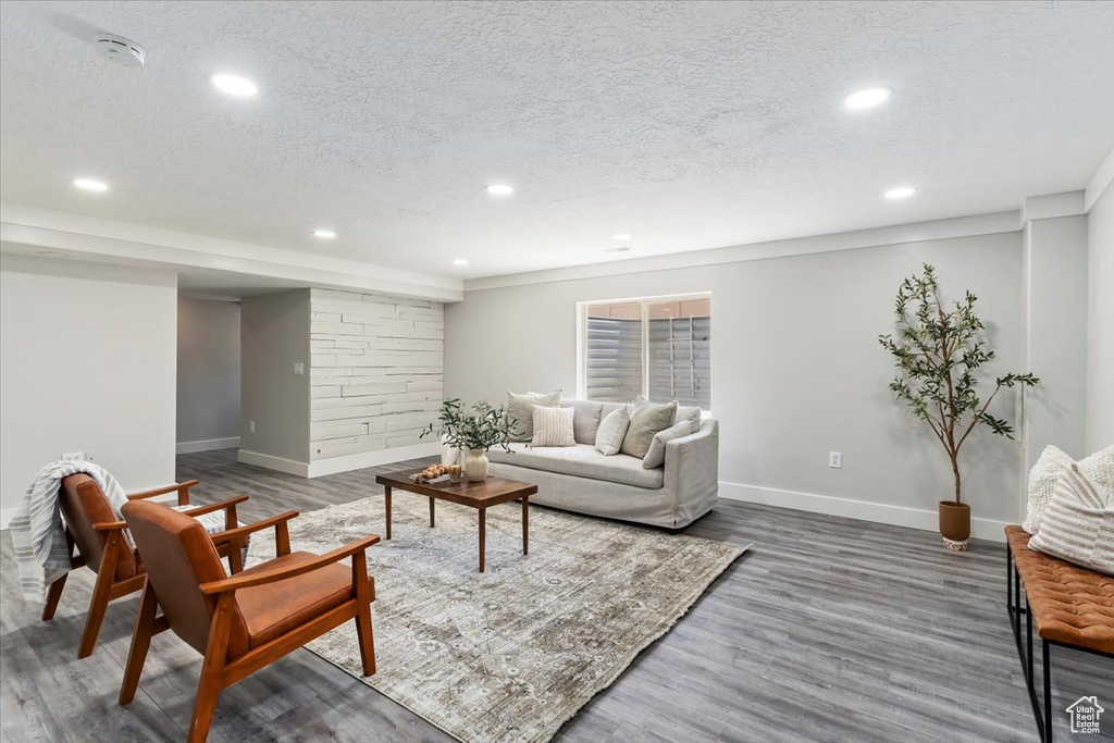Living area with wood finished floors, recessed lighting, and a textured ceiling