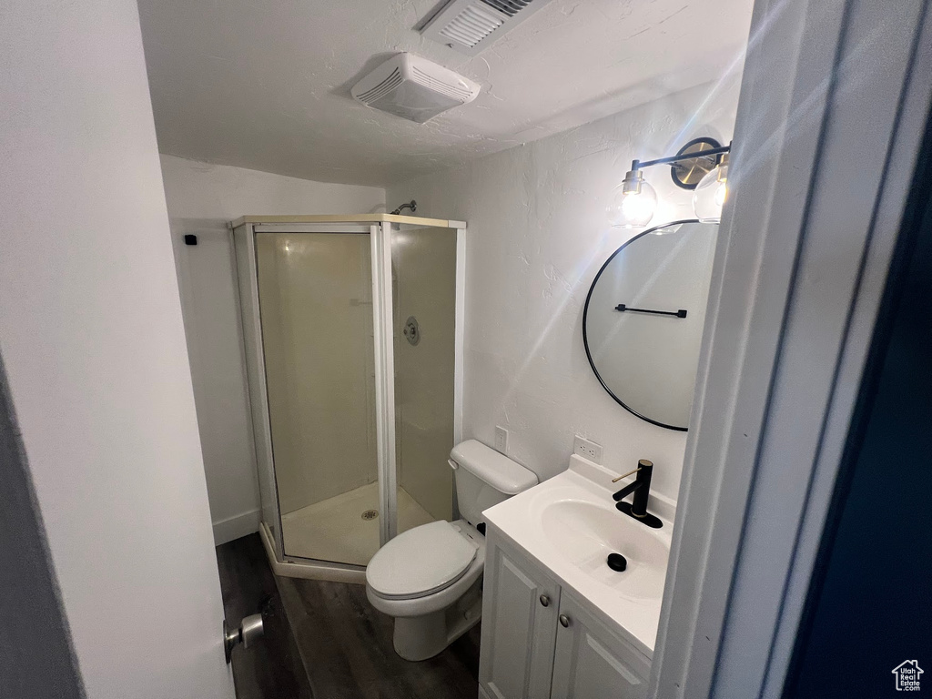 Bathroom with vanity, hardwood / wood-style flooring, toilet, and walk in shower