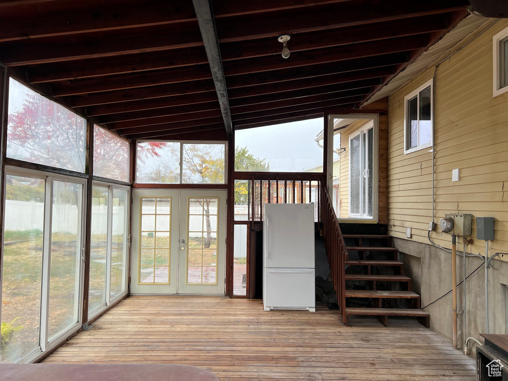 Unfurnished sunroom with vaulted ceiling with beams