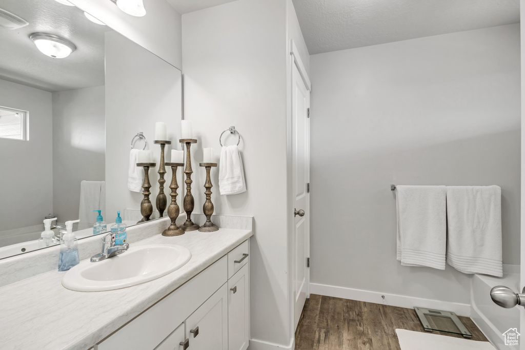 Bathroom with vanity, hardwood / wood-style floors, and a textured ceiling