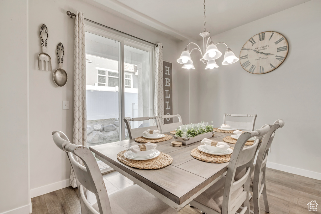 Dining area with hardwood / wood-style flooring and an inviting chandelier