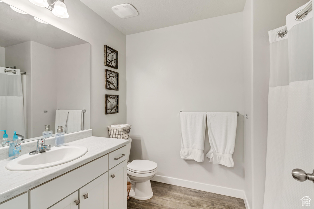 Bathroom featuring vanity, wood-type flooring, and toilet