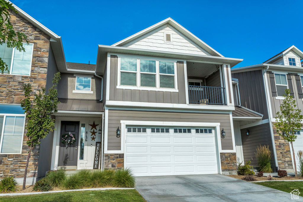 View of front facade with a balcony and a garage