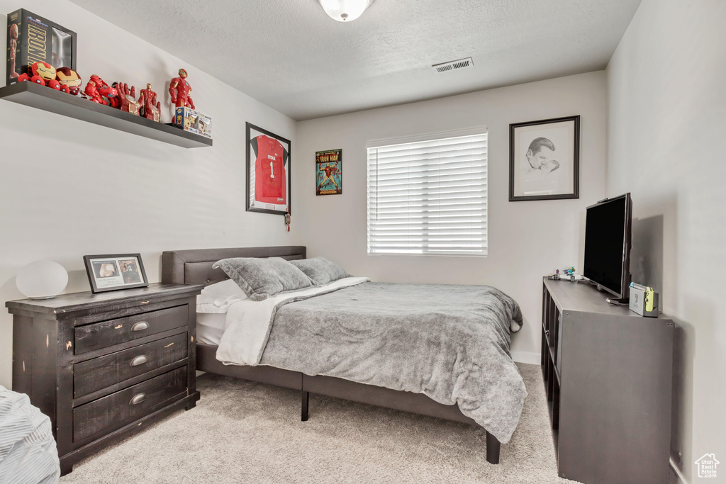 Carpeted bedroom featuring a textured ceiling