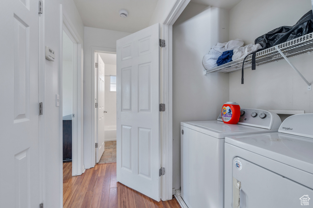 Laundry area with washing machine and dryer and light wood-type flooring