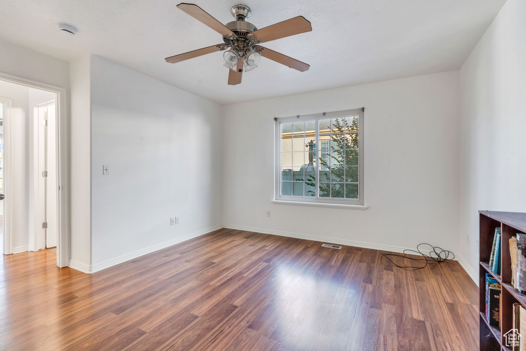 Unfurnished room featuring ceiling fan and dark hardwood / wood-style flooring