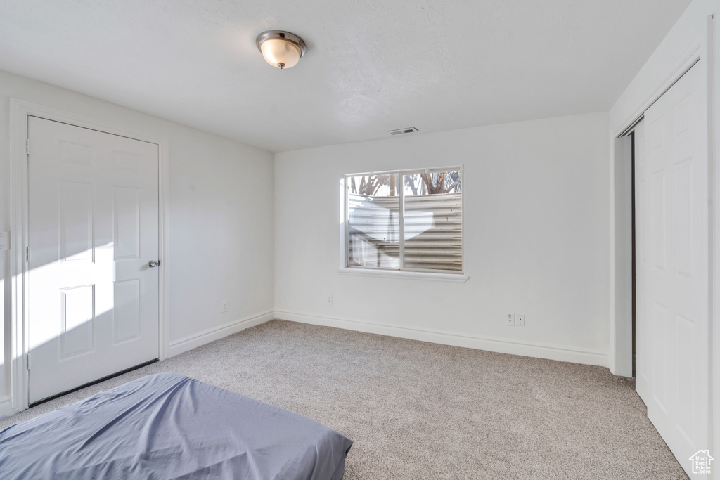 Bedroom with a closet and light colored carpet