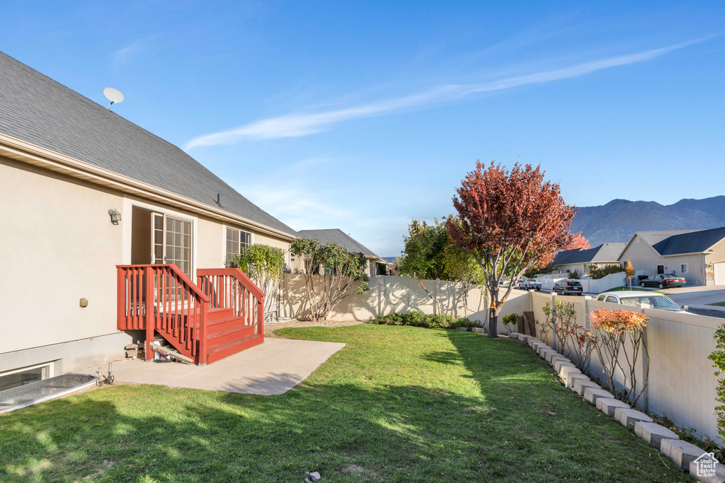 View of yard with a deck with mountain view