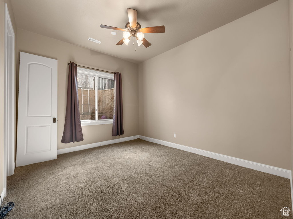 Unfurnished room featuring carpet and ceiling fan