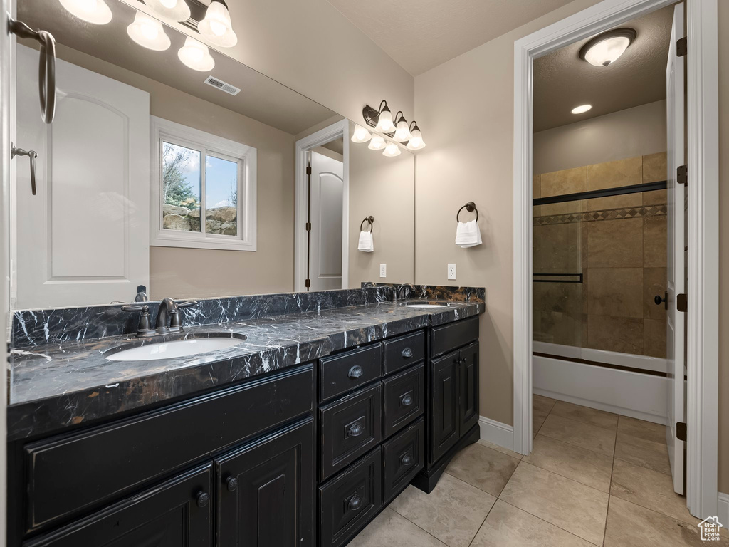 Bathroom with vanity, enclosed tub / shower combo, and tile patterned floors