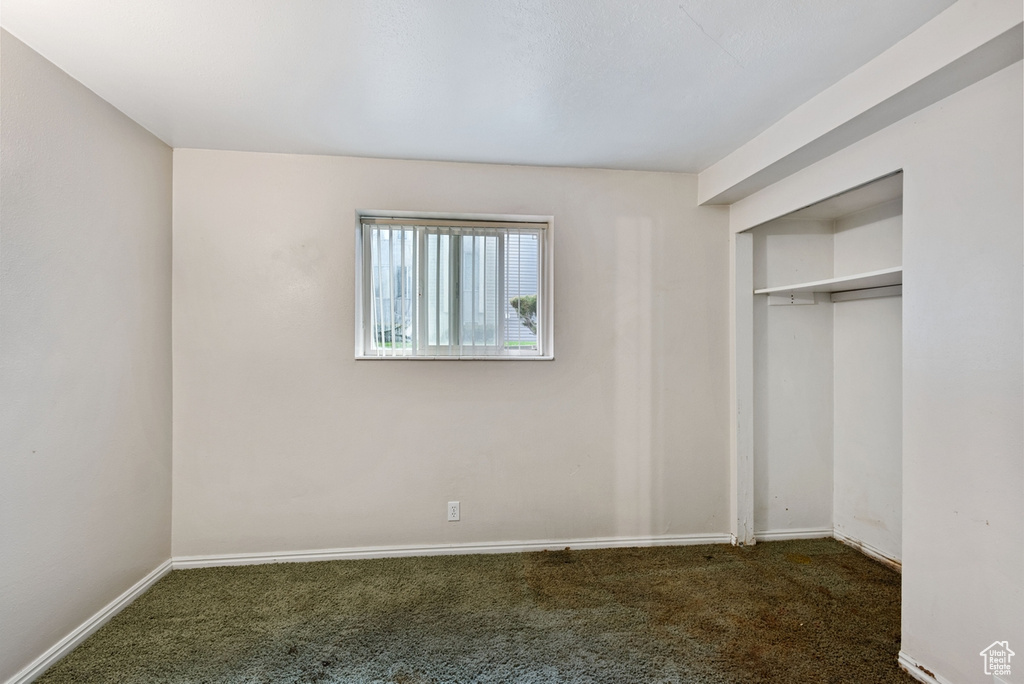 Unfurnished bedroom with a closet and dark colored carpet