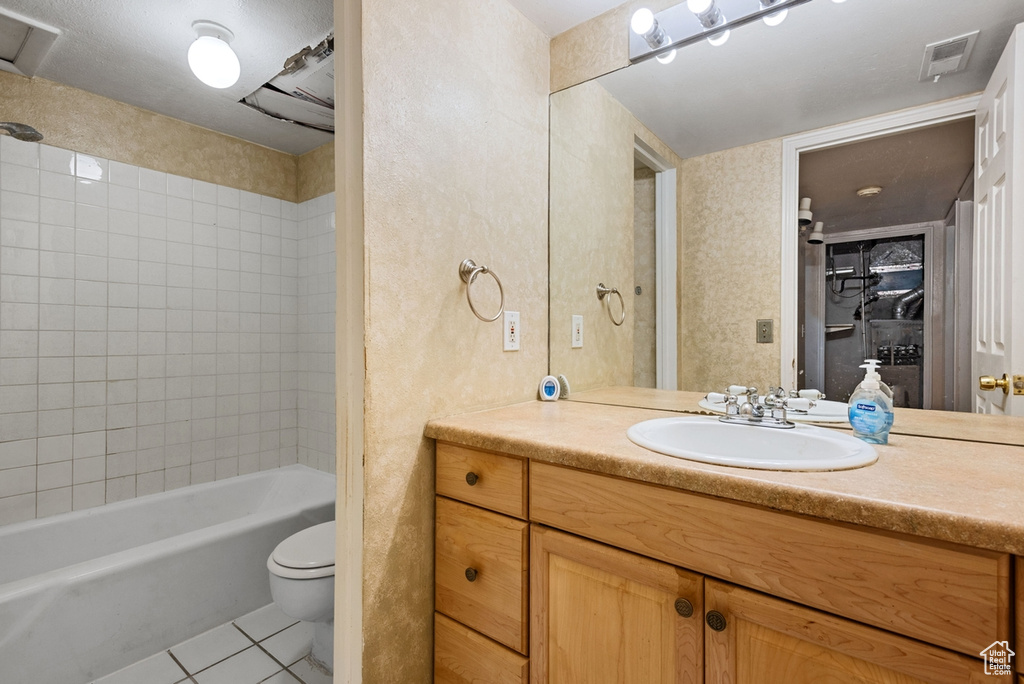 Full bathroom featuring vanity, tiled shower / bath, toilet, and tile patterned floors