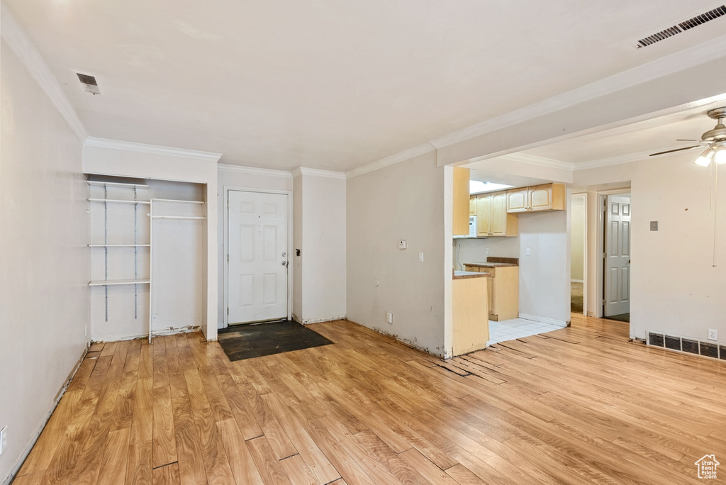 Entryway with crown molding and light hardwood / wood-style floors