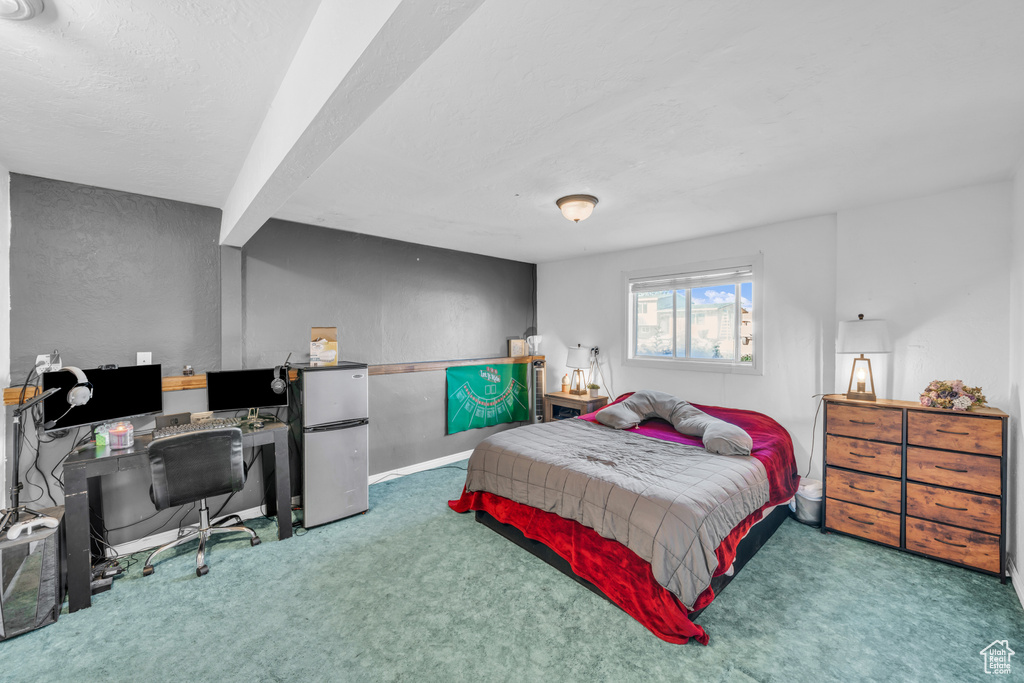 Bedroom with carpet flooring and fridge