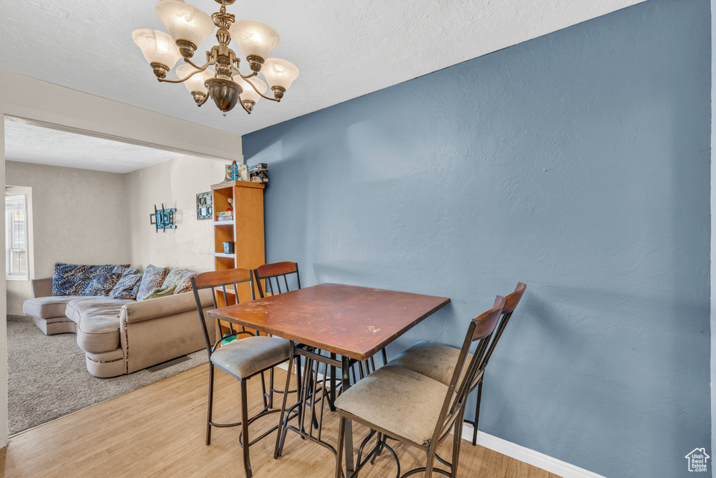 Dining room with a notable chandelier and light hardwood / wood-style floors