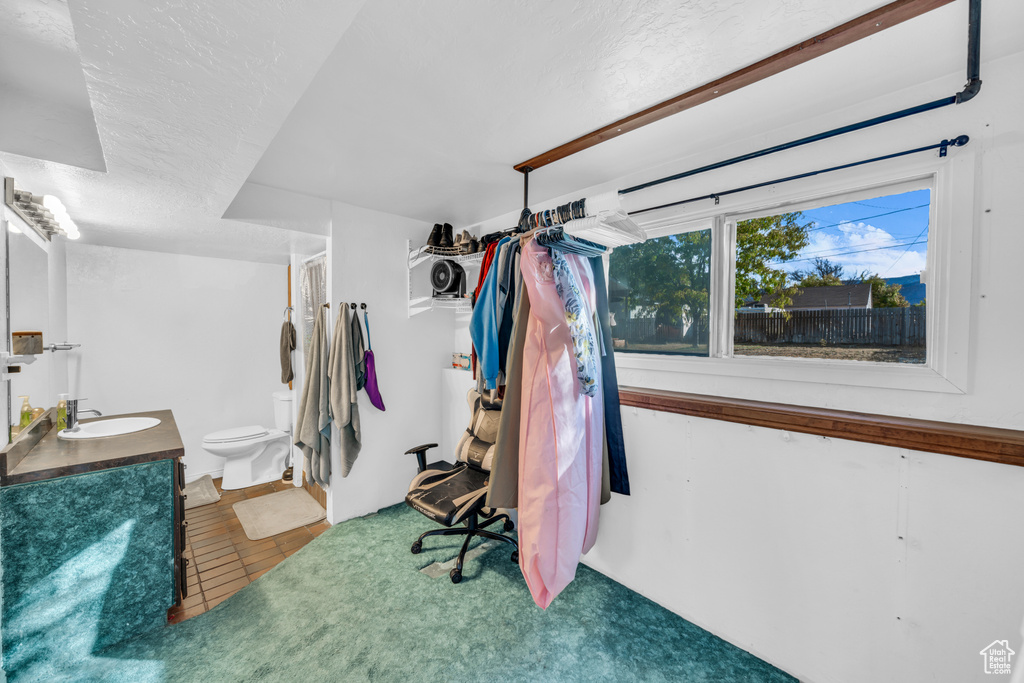 Bathroom with vanity, toilet, and a textured ceiling