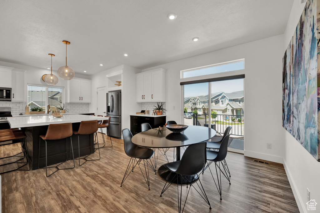 Dining space with hardwood / wood-style floors