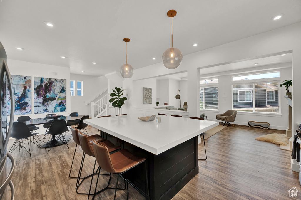 Kitchen with a kitchen island, a breakfast bar, pendant lighting, and light hardwood / wood-style floors