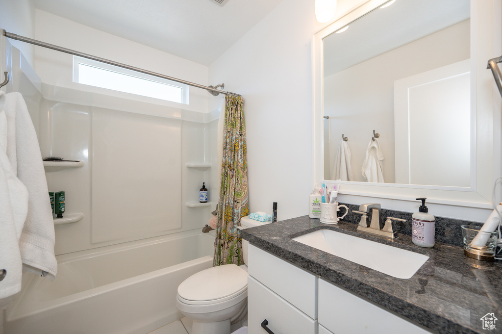 Full bathroom featuring toilet, shower / tub combo with curtain, vanity, and tile patterned flooring