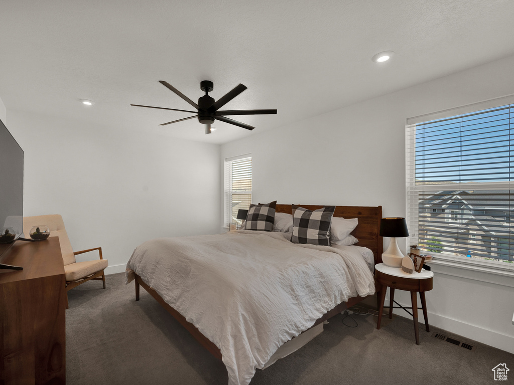 Bedroom with ceiling fan and dark carpet