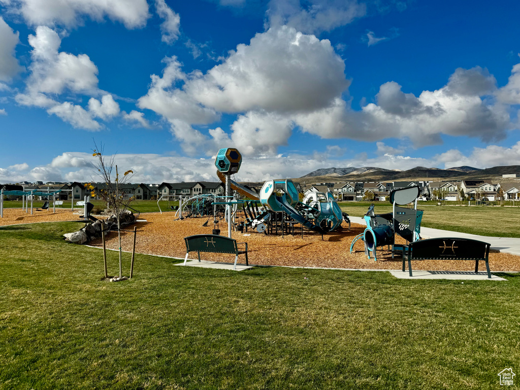 View of playground with a mountain view and a lawn