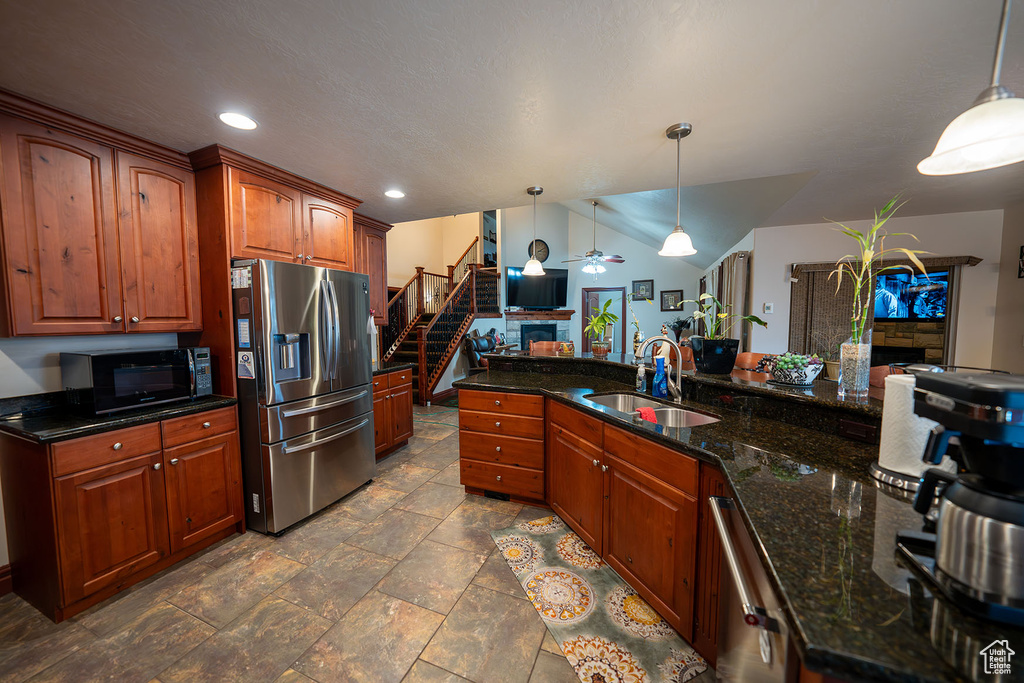 Kitchen with stainless steel appliances, lofted ceiling, sink, and pendant lighting