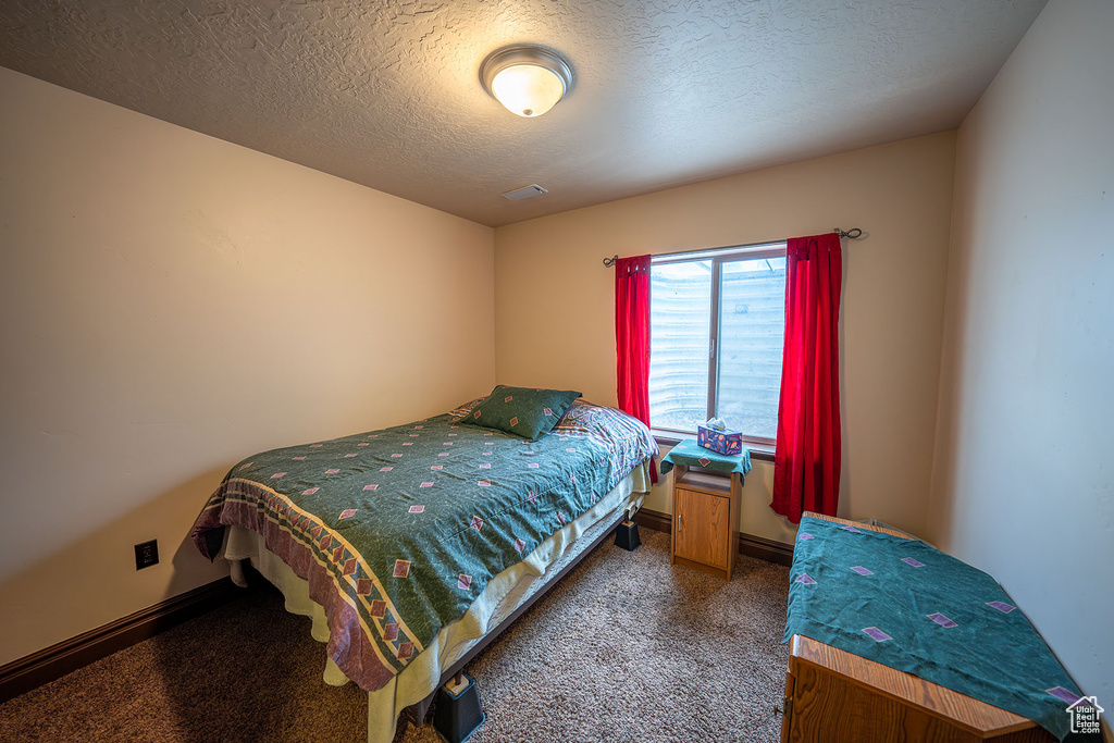 Bedroom with carpet and a textured ceiling