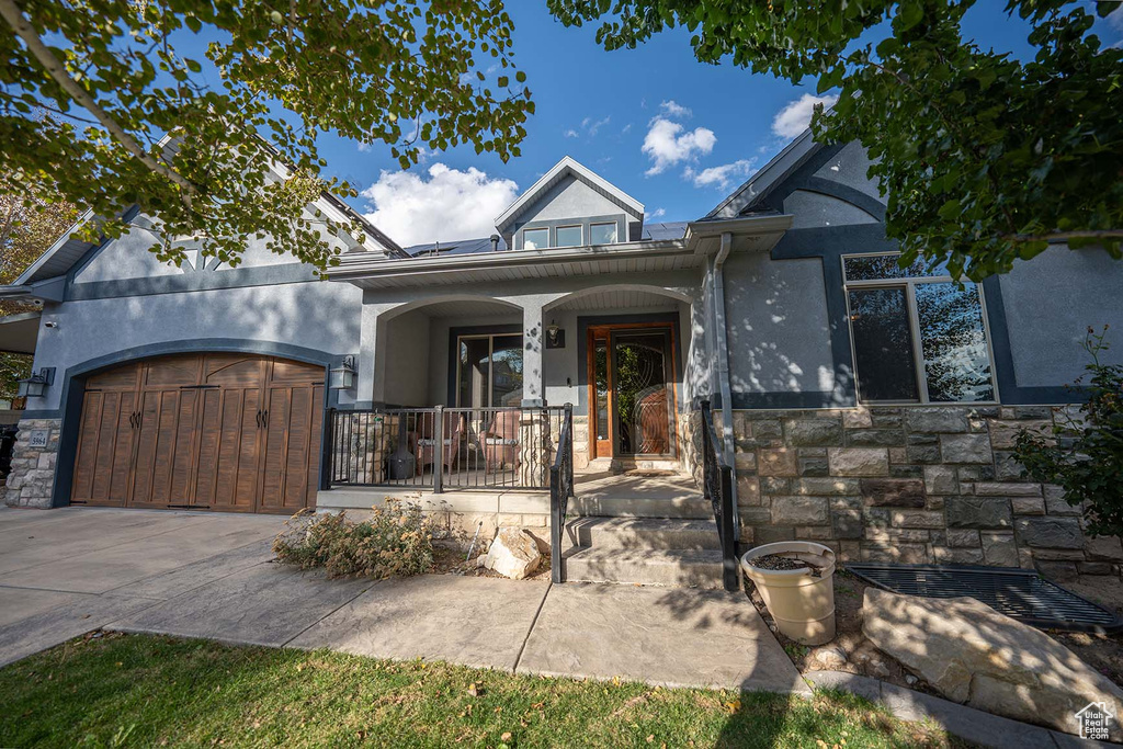 View of front of property featuring covered porch and a garage