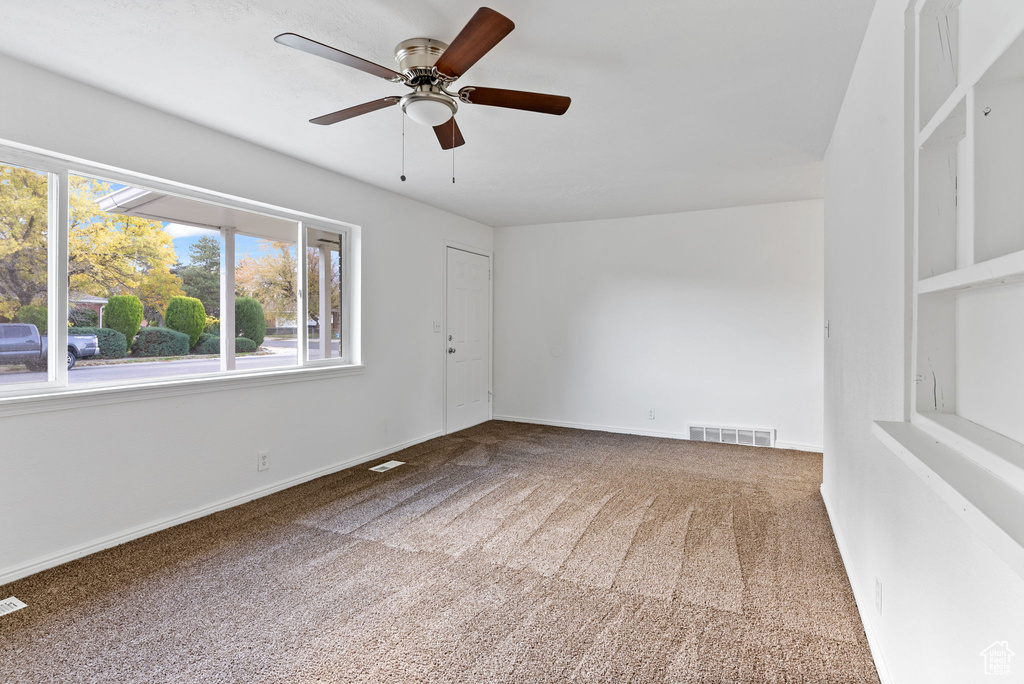 Spare room featuring carpet floors and ceiling fan