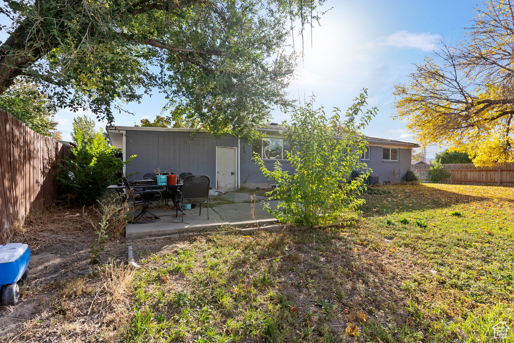 Back of house with a patio area and a lawn