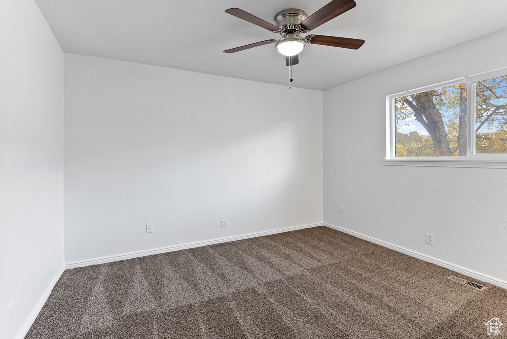 Carpeted spare room with ceiling fan