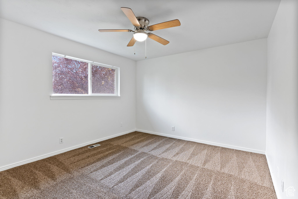 Empty room with carpet and ceiling fan