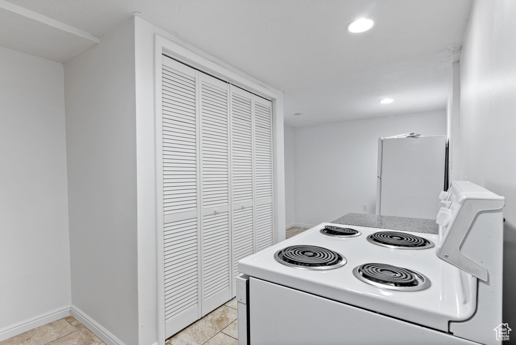 Kitchen with electric range and light tile patterned floors