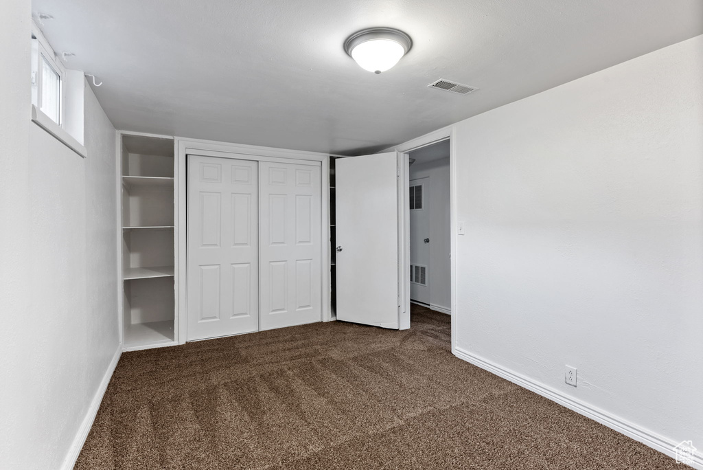 Unfurnished bedroom featuring a closet and carpet floors