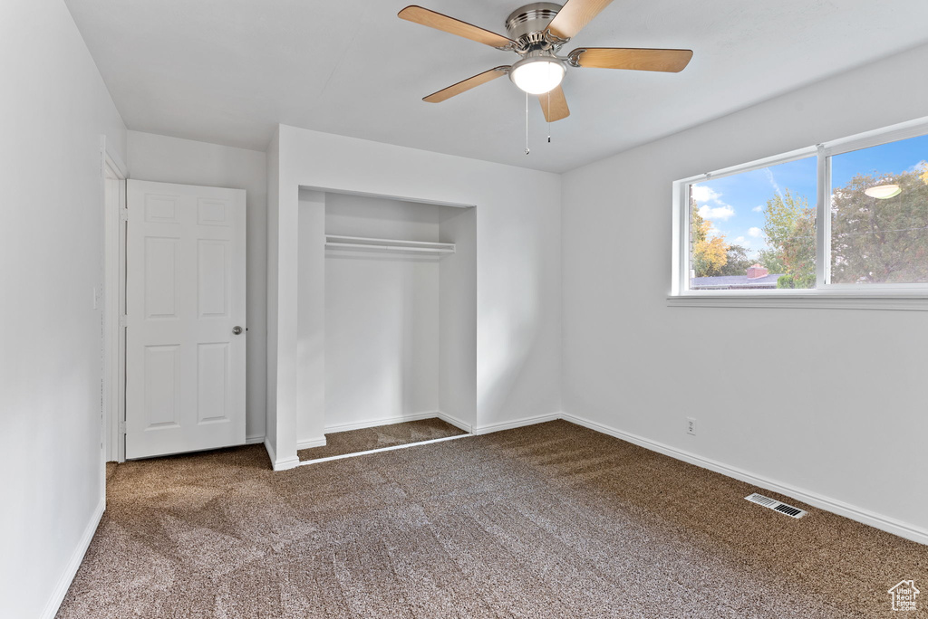 Unfurnished bedroom featuring carpet, a closet, and ceiling fan