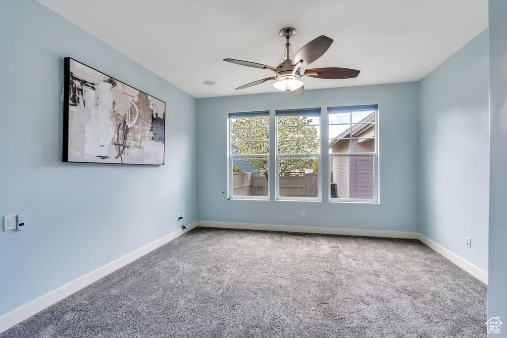 Spare room with carpet floors, baseboards, and ceiling fan