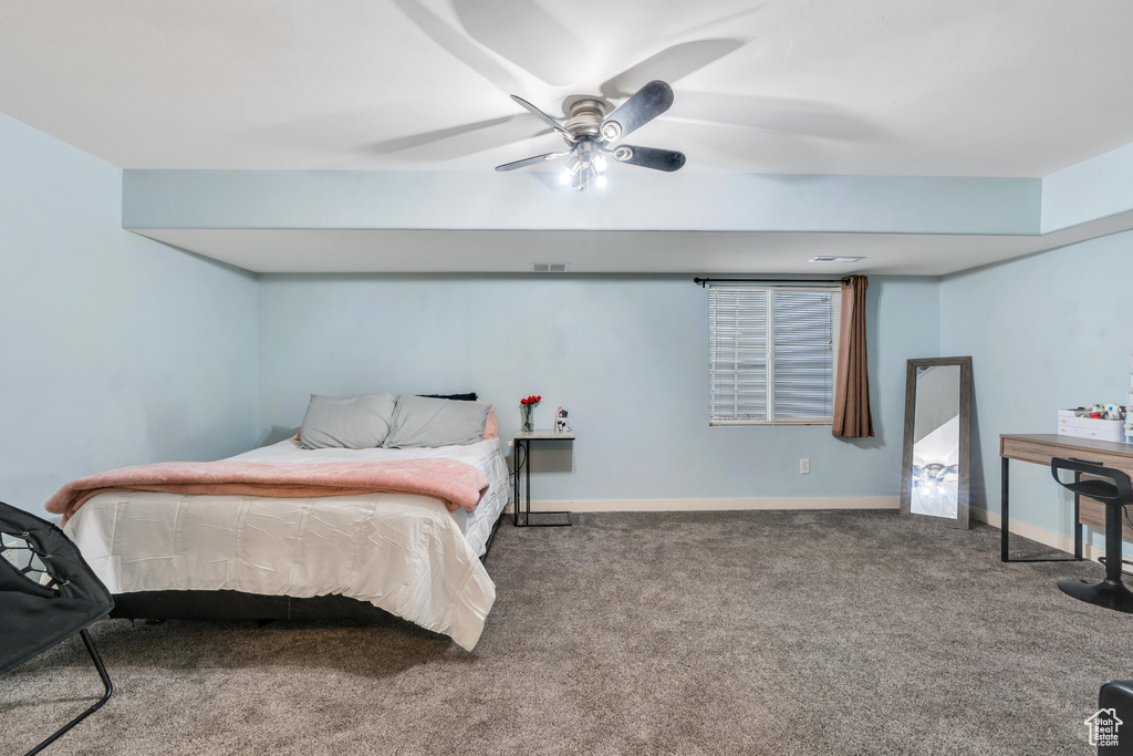 Carpeted bedroom with baseboards, visible vents, and ceiling fan