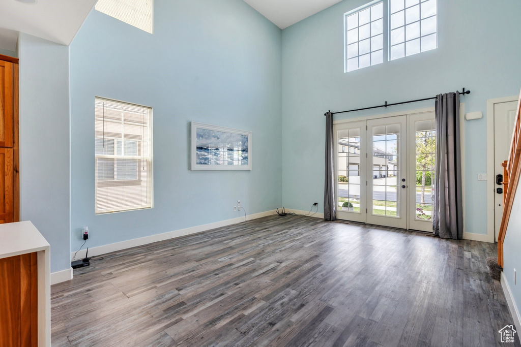 Interior space with baseboards, wood finished floors, and a towering ceiling