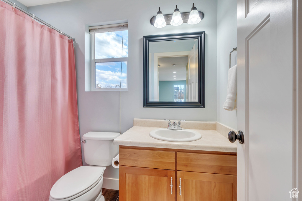 Full bath with vanity, curtained shower, and toilet