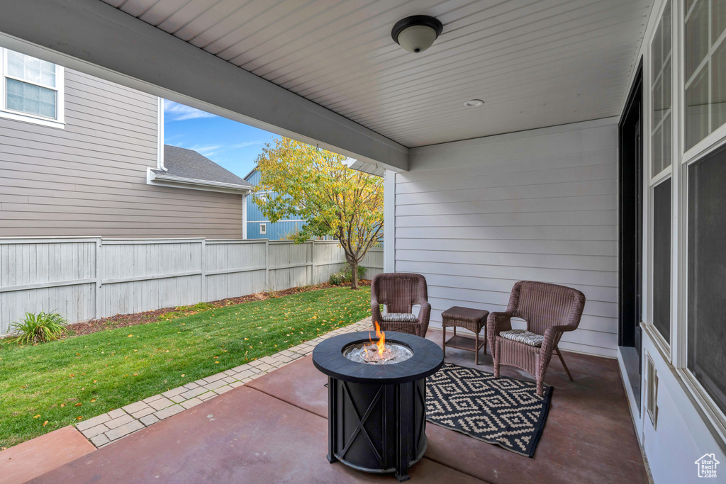 View of patio featuring an outdoor fire pit and fence