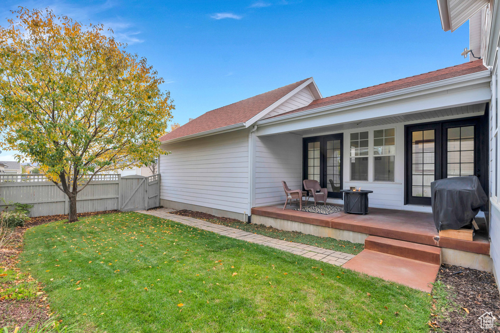 Rear view of property with a lawn, a gate, fence, and a shingled roof