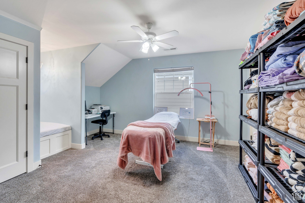 Carpeted bedroom featuring a ceiling fan, lofted ceiling, and visible vents