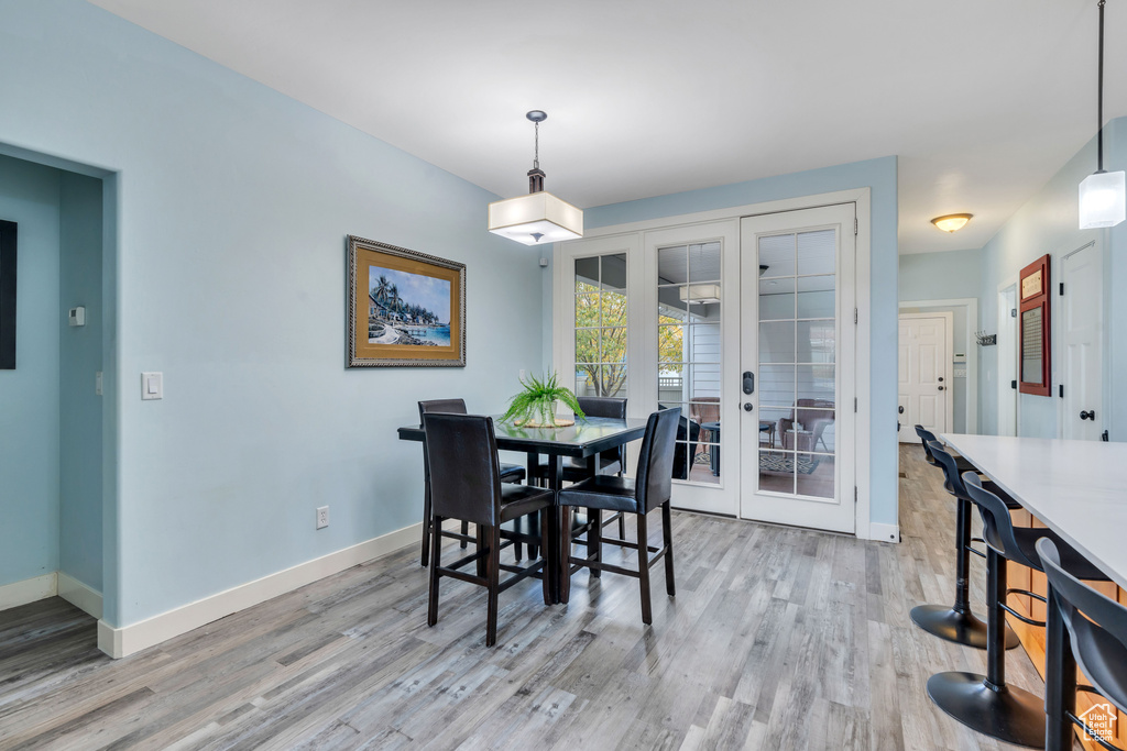 Dining space featuring french doors, baseboards, and light wood-type flooring
