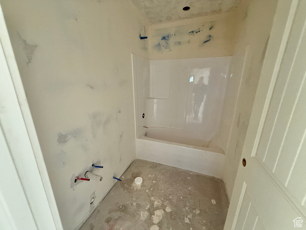 Bathroom featuring concrete flooring and shower / bathing tub combination