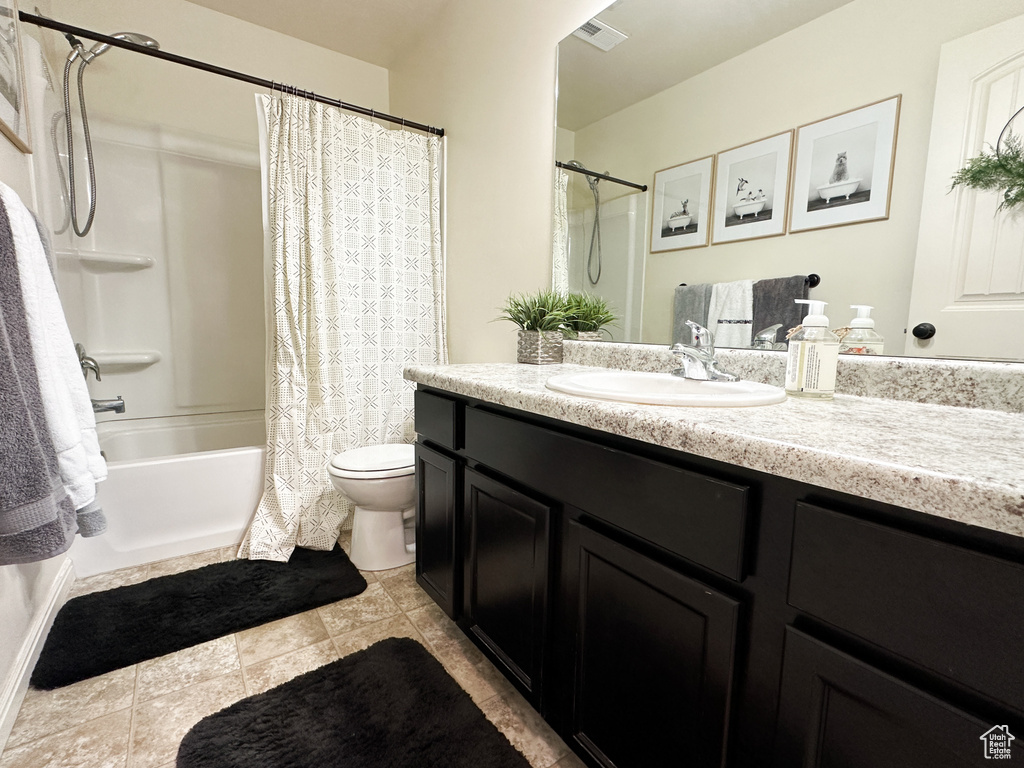 Full bathroom featuring vanity, toilet, shower / bath combo, and tile patterned flooring