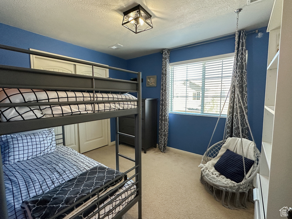 Carpeted bedroom featuring a textured ceiling